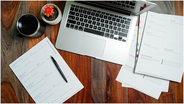 Top view of laptop with paperwork about creating a business and implementing content networking as a marketing strategy